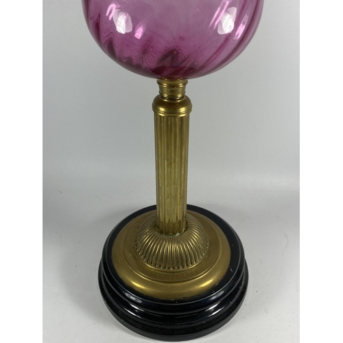 21 - A VINTAGE BRASS CORINTHIAN COLUMN OIL LAMP WITH CRANBERRY GLASS RESEVOIR, HEIGHT 71CM