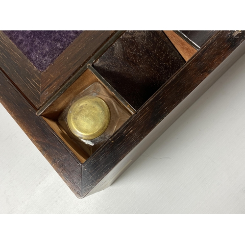 25 - A VINTAGE MAHOGANY AND BRASS BOUND WRITING SLOPE WITH TWO BRASS TOPPED INKWELLS AND INNER VELVET SLO... 