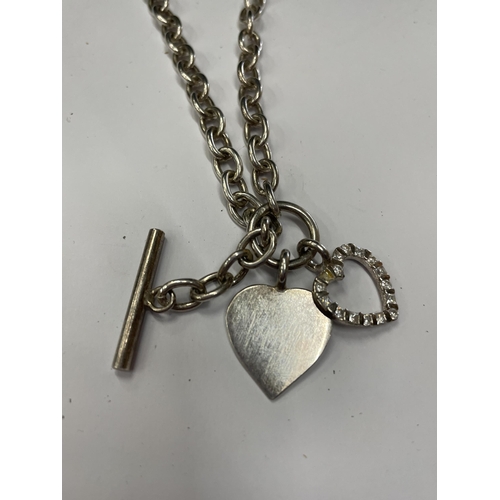 663 - A SILVER T BAR NECKLACE WITH TWO HEART CHARMS