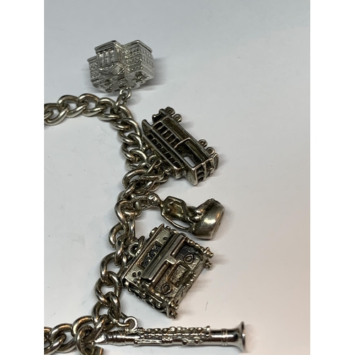 671 - A SILVER BRACELET WITH ELEVEN CHARMS AND A HEART PADLOCK