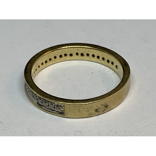 690 - A 9 CART GOLD RING WITH A BAND OF DIAMONDS SIZE K