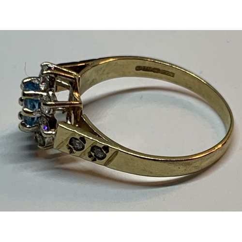 693 - A 9 CARAT GOLD RING WITH A BLUE TOPAZ SURROUNDED BY CUBIC ZIRCONIAS SIZE K/L