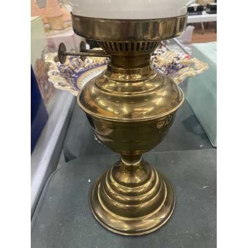 121 - A VINTAGE BRASS OIL LAMP WITH CLEAR GLASS CHIMNEY AND OPAQUE ROUND SHADE HEIGHT APPROX 50CM