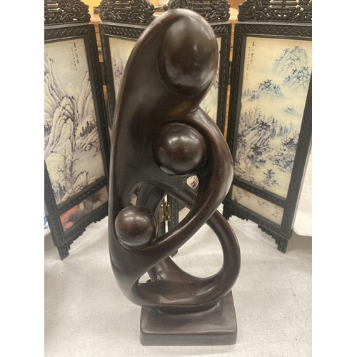 426 - AN ABSTRACT 'MOTHER AND CHILD' SCULPTURE PLUS A SMALL ORIENTAL STYLE SCREEN