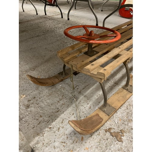 255 - A VINTAGE WOODEN SLEDGE WITH A STEERING WHEEL