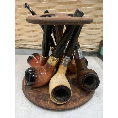 274 - A WOODEN PIPE STAND CONTAINING SIX PIPES - TWO WITH SILVER COLLARS - PLUS FOUR LAXEY PIPES BLOCK MEE... 