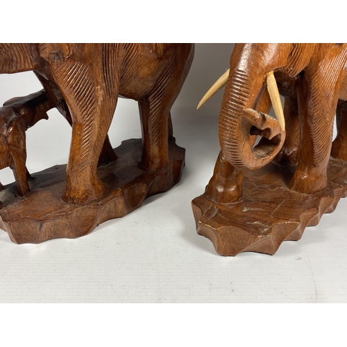 18 - A PAIR OF VINTAGE CARVED WOODEN TRIBAL FAMILY OF ELEPHANT FIGURES, HEIGTH 27CM