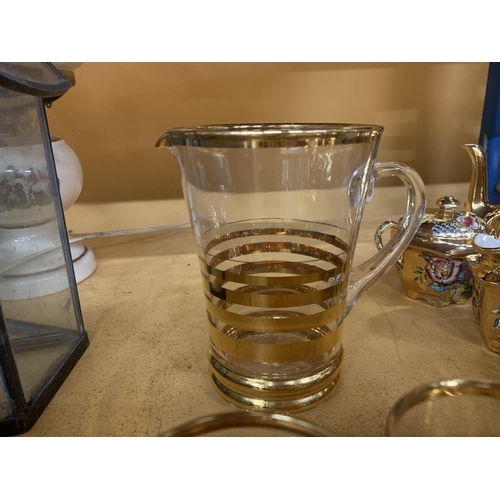 852 - A LEMONADE SET WITH A JUG AND SIX GLASSES WITH A STRIPY GOLD COLOURED PATTERN