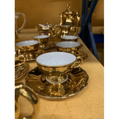 854 - A GOLD COLOURED GERMAN TEASET TO INCLUDE A TEAPOT, CREAM JUG, SUGAR BOWL, CUPS AND SAUCERS PLUS A FL... 