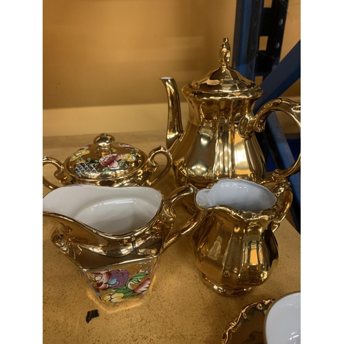 854 - A GOLD COLOURED GERMAN TEASET TO INCLUDE A TEAPOT, CREAM JUG, SUGAR BOWL, CUPS AND SAUCERS PLUS A FL... 