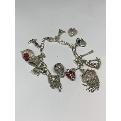 592 - A SILVER CHARM BRACELET WITH FOURTEEN CHARMS