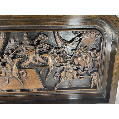 428 - A LARGE HEAVILY CARVED ORIENTAL PLAQUE DEPICTING WARRIOR DESIGN, 91 X 46CM