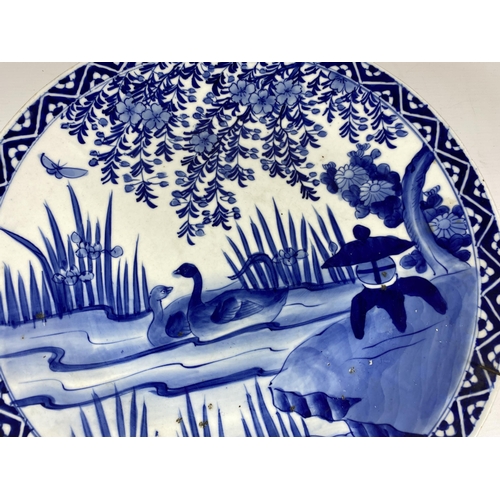 450 - A LARGE JAPANESE EARLY 20TH CENTURY BLUE AND WHITE CHARGER WITH DUCKS IN POND DESIGN, DIAMETER 37CM