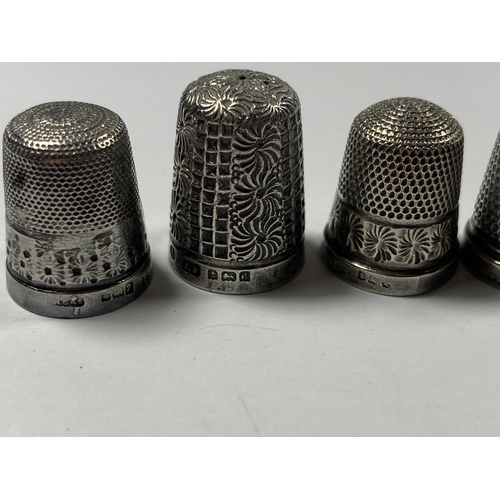 520 - A GROUP OF THREE HALLMARKED SILVER THIMBLES AND FURTHER PLATED EXAMPLE