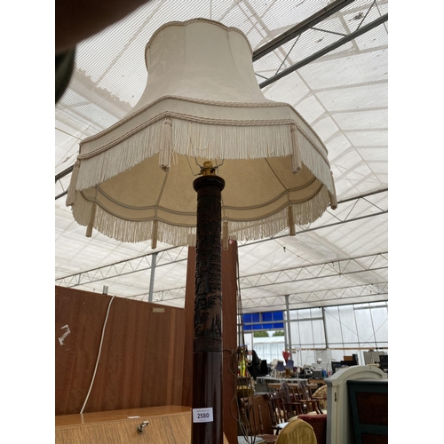 2580 - AN ORIENTAL HARDWOOD STANDARD LAMP COMPLETE WITH SHADE