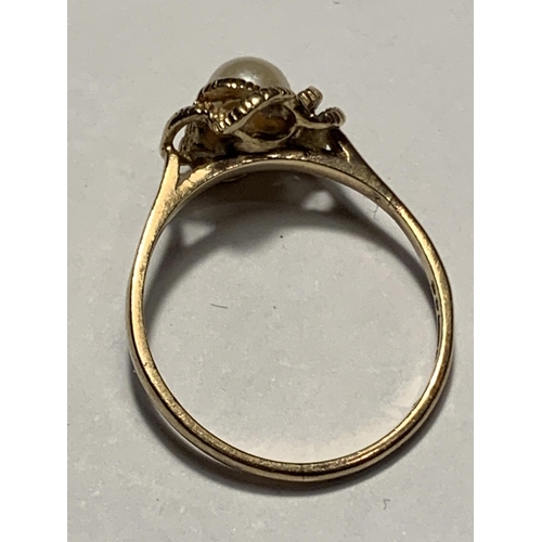 529 - A 9 CARAT GOLD RING WITH A CENTRE PEARL IN A TWIST DESIGN SIZE O/P