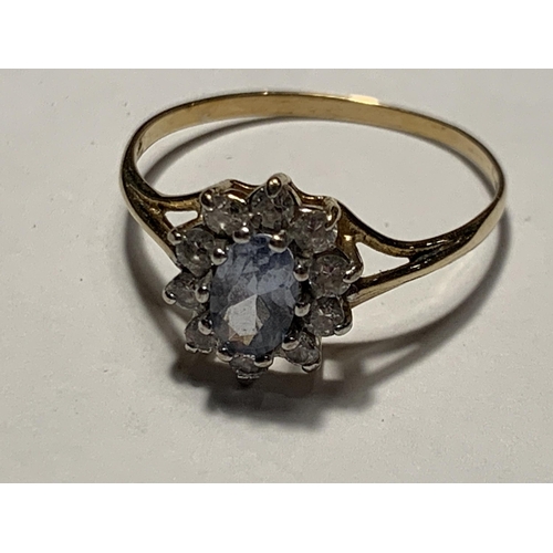 675 - A 9 CARAT GOLD RING WITHB A CENTRE AQAUAMARINE SURROUNDED BY CUBIC ZIRCONIAS  SIZE Q/R