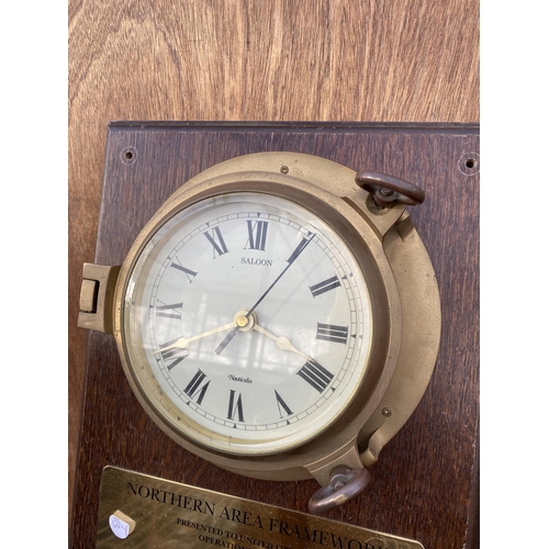 1536 - A BRASS PORTHOLE STYLE SALOON WALL CLOCK WITH WOODEN MOUNT BEARING THE PLAQUE 'NORTHERN AREA FRAMEWO... 