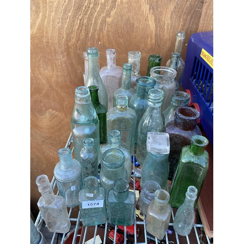 1574 - A LARGE ASSORTMENT OF VINTAGE GLASS BOTTLES TO INCLUDE SOME NAMED