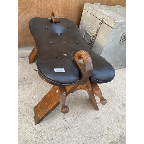 1587 - A WOODEN AND LEATHER TOPPED SADDLE STYLE STOOL