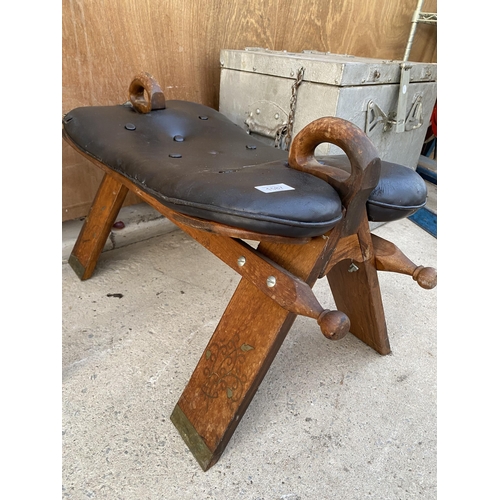 1587 - A WOODEN AND LEATHER TOPPED SADDLE STYLE STOOL