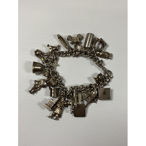 695 - A SILVER CHARM BRACELET WITH ASSORTED CHARMS