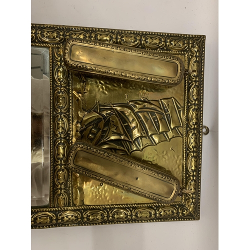 223 - A VINTAGE BRASS FRAMED MIRROR WITH GALLEON TOP AND TWO BRUSHES