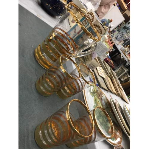 1051 - A LEMONADE SET WITH A JUG AND SIX GLASSES WITH A STRIPY GOLD COLOURED PATTERN