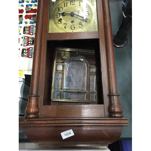 1058 - A MAHOGANY FRAMED WALL CLOCK WITH BEVELLED GLASS DOOR, PENDULUM AND KEY IN NEED OF SOME RESTORATION ... 