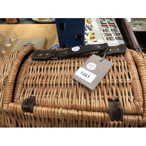 1061 - AN UNUSUAL OVOID SHAPED WICKER  PICNIC BASKET WITH ACCESSORIES