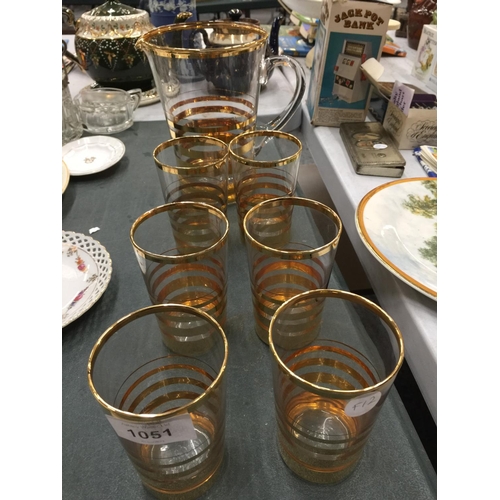 1051 - A LEMONADE SET WITH A JUG AND SIX GLASSES WITH A STRIPY GOLD COLOURED PATTERN