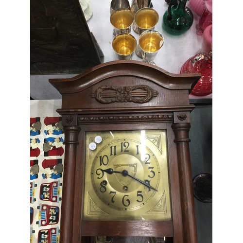 1058 - A MAHOGANY FRAMED WALL CLOCK WITH BEVELLED GLASS DOOR, PENDULUM AND KEY IN NEED OF SOME RESTORATION ... 