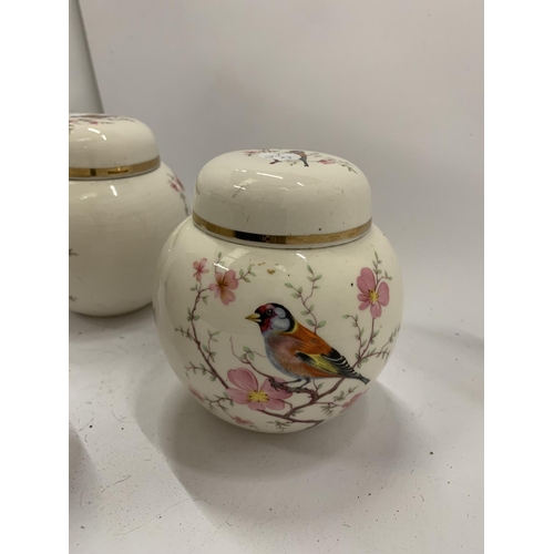 131 - TWO ARTHUR WOOD GINGER JARS AND A TEMPLE JAR WITH BIRDS AND BLOSSOM DESIGN