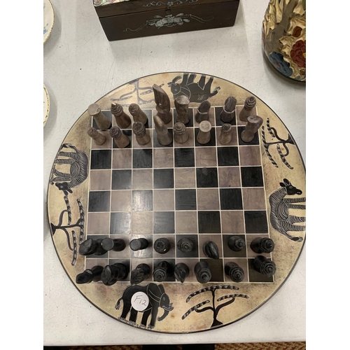 277 - A STONE CHESS BOARD AND PIECES WITH AFRICAN ANIMALS DESIGN AND STONE CHESS PIECES