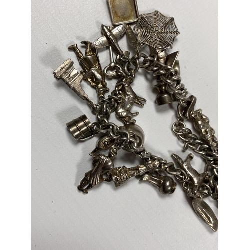 695 - A SILVER CHARM BRACELET WITH ASSORTED CHARMS