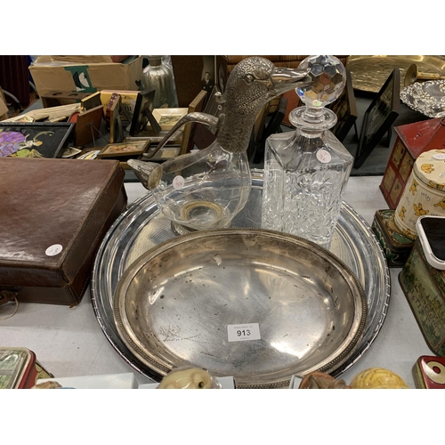 913 - A GLASS AND SILVER PLATED WATER JUG WITH DUCK HEAD, A CUT GLASS DECANTER PLUS TWO SILVER PLATED TRAY... 