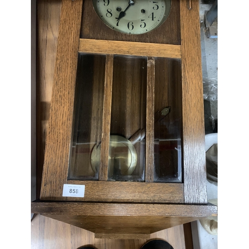 858 - AN OAK CASED WALL CLOCK WITH PENDULUM AND KEY