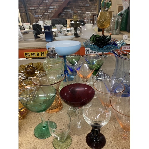 869 - A LARGE QUANTITY OF COLOURED GLASSWARE TO INCLUDE VARIOUS GLASSES, JUGS, PEDESTAL BOWLS, FRUIT, COCK... 