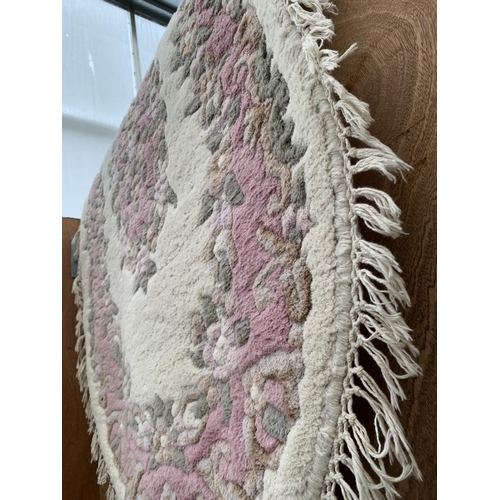 2489 - A CREAM AND PINK OVAL FRINGED RUG