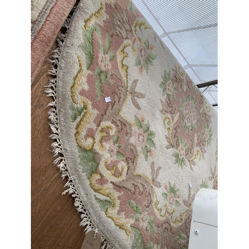 2494 - A PINK FRINGED RUG AND A FURTHER OVAL PATERNED FRINGED RUG