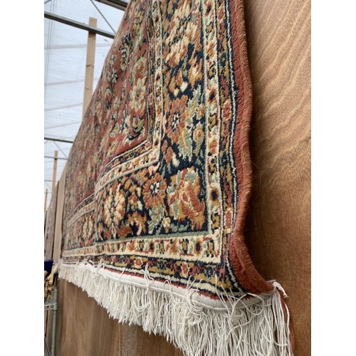 2497 - AN ORANGE PATTERNED FRINGED RUG