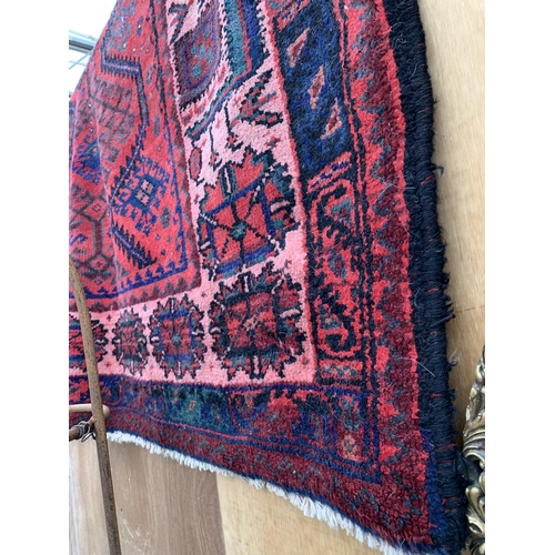 2499 - A RED PATTERNED FRINGED RUG