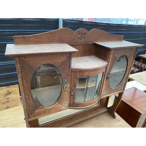 2956 - AN OAK ART NOUVEAU MIRROR BACK SIDEBOARD WITH OVAL GLASS DOORS TO UPPER PORTAL 43 INCH WIDE