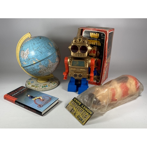 312 - FOUR ITEMS - A BOXED ELECTRONIC SPACE MONSTER, PLASTIC FRED FLINTSTONE MONEY BANK, BOOK & TIN GLOBE