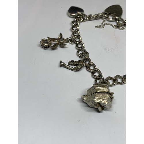 545 - A SILVER BRACELET WITH SEVEN VARIOUS CHARMS