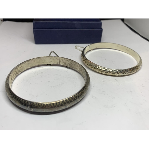 551 - TWO SILVER BANGLES WITH SAFETY CHAINS IN A PRESENTATION BOX