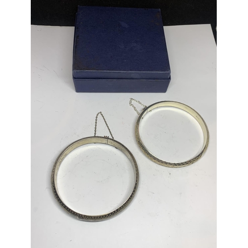 551 - TWO SILVER BANGLES WITH SAFETY CHAINS IN A PRESENTATION BOX