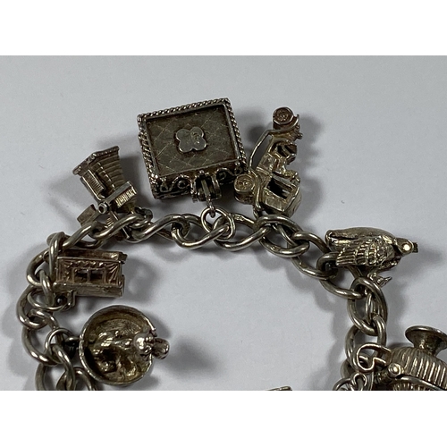 523 - A SILVER HEART PADLOCK CHARM BRACELET WITH NINE CHARMS