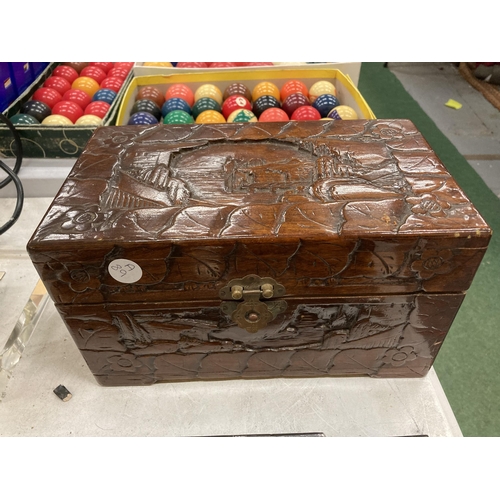 183 - A HEAVILY CARVED JEWELLERY BOX CONTAINING GOOD QUALITY COSTUME JEWELLERY