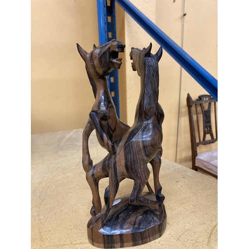 244 - A HARDWOOD SCULPTURE OF FIGHTING HORSES